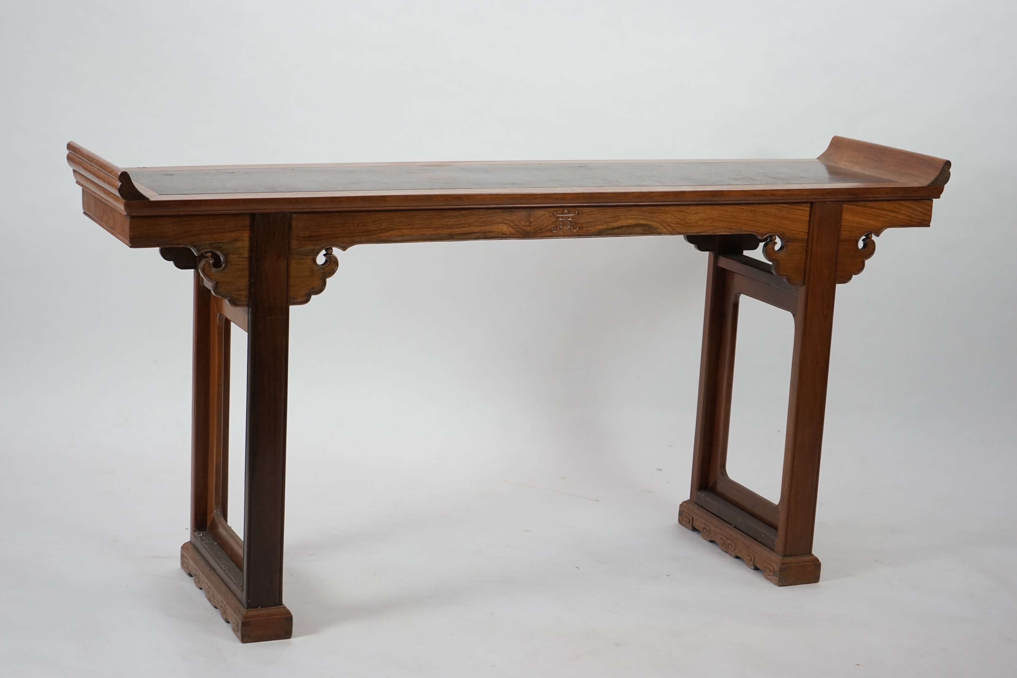 A Chinese padouk wood and jichimu altar table, the panelled rectangular top with scroll ends, on plain uprights headed by ruyi, 185cm wide, 94cm high. Condition - fair to good